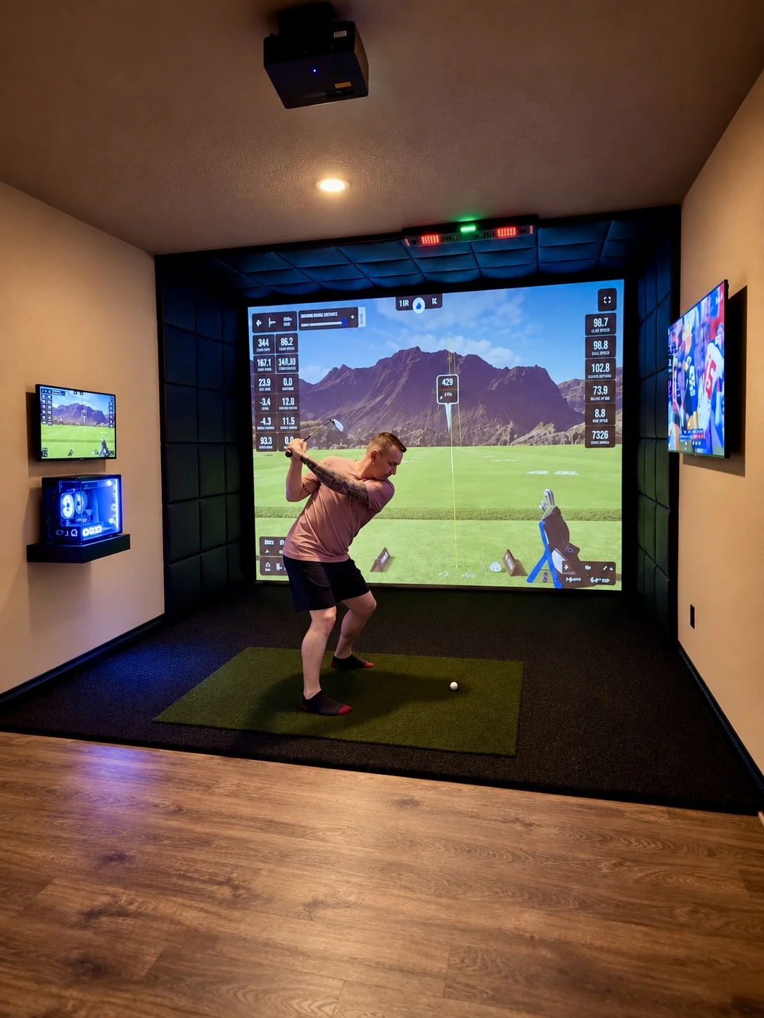 Golfer taking a swing in a completed SIMHAUS indoor golf simulator